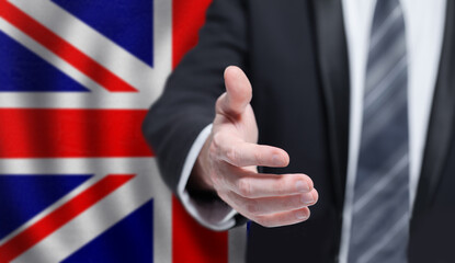 Welcome to the UK. Hand on flag background. Business, politics, cooperation and travel concept