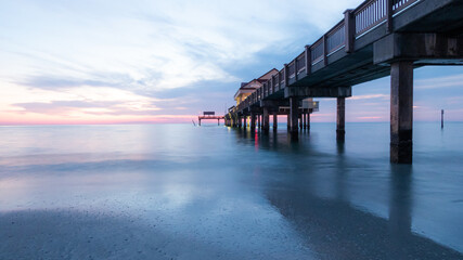 Pier at sunset on the beautiful silky waters on Clearwater beach in Florida.