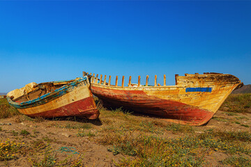 Fototapeta na wymiar the wrecks of boats on the sandy shore next to the sea