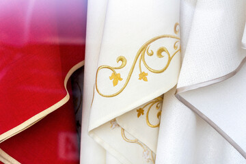 Set of different catholic church priest chasubles, vestments, traditional robes, priest's religious clothing, clothes simple concept, detail, extreme closeup, nobody. Christianity, catholic culture - obrazy, fototapety, plakaty