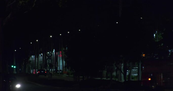 Firetruck driving through night streets with blinking lights in USA - tilt shot