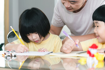 Cute Asia boys do homework with father at home	