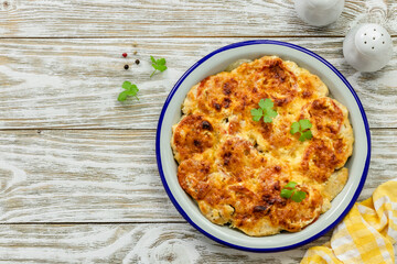 Chicken vegetable bake on wooden background. Top view, copy space, flat lay.