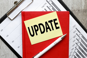 Update text on a yellow sticky note on a folder with financial charts