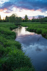 Small river with sunset reflection on a calm late spring evening in Estonia, Northern Europe