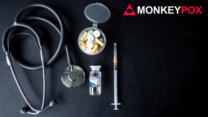 MONKEYPOX. Vaccine against smallpox and monkeypox. Stethoscope, pills, syringe, vaccine. Virus, epidemic, disease. Black background.