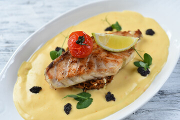 grilled fish fillet with vegetable puree, tomatoes and lemon