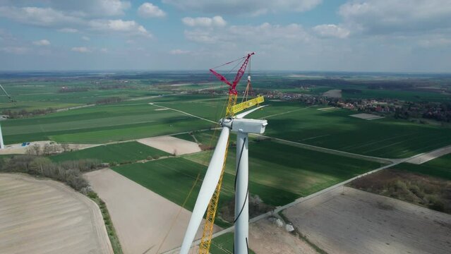The wind farm during construction, the crane lifts a huge propeller, which the fitter sitting upstairs will tighten.