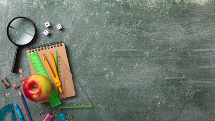 School background with school supplies and copy space. Top view, pens and pencils, notebooks, green...