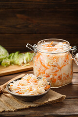 Fresh pickled cabbage - sauerkraut with carrot on a wooden table.
