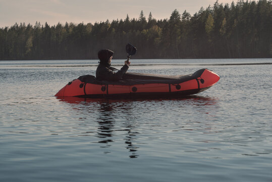 A man paddles on an inflatable boat packraft