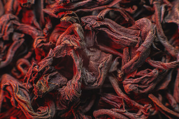 Black loose leaf tea on a red light as a background. Texture of dry black tea leaves. Dark background. Extreme macro mode. black leaf tea closeup