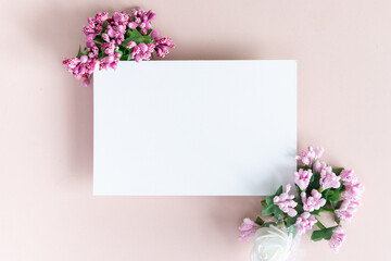 Mock up of invitation to wedding. Handmade greeting card. Frame with gentle pink flowers on a pale pink background. 