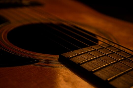 Guitar.Guitar's chords.Acoustic guitar.Music.Music background.Image of an acoustic guitar in the dark.Playing music with some friends in the dark.Classical music.Guitar closeup..