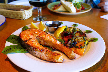Fried salmon with lemon and vegetables. Serving the dish. Shallow depth of field - 508086910
