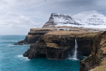 Fototapeta na wymiar un village et une cascade au îles Féroé dans l'atlantique Nord