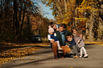 Fototapeta premium Father with four kids at autumn park.