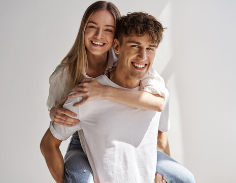 Portrait of lovely couple having fun while man piggybacking his girlfriend