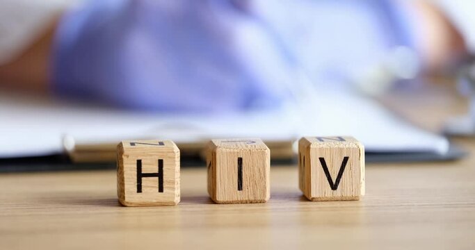 HIV text on cubes against background of working doctor