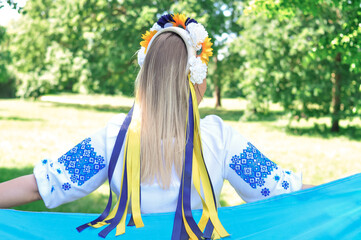 Ukrainian girl with a yellow and blue national flag of Ukraine - obrazy, fototapety, plakaty