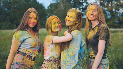 Fototapeta premium Cheerful girls posing smeared in multi-colored powder.