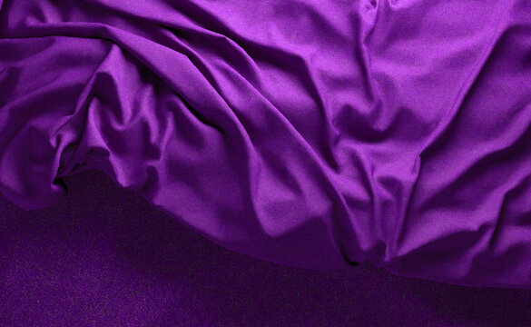 Fondo de tela en color morado con arrugas y pliegues. Ropa de cama y sábanas.