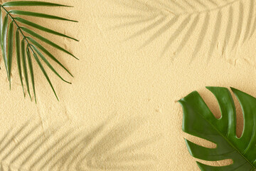 Fototapeta na wymiar Summer day scene with green tropical leaves and shadows on sand background. Flat lay. Minimal summer exotic concept with copy space.
