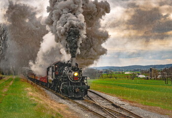 Obraz na płótnie Canvas An Antique Steam Passenger Train Traveling Thru Farmlands Puffing Lots of Smoke on a Cloudy Winter Day