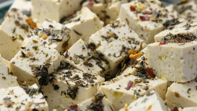 Eating Vegan Tofu feta cheese with dried oregano, basil, thyme and garlic