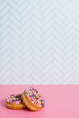 two strawberry sprinkle donuts