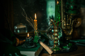 Illustration of magical stuff....candle light, Chrystal ball, magic wand, book of spells dark background, Slytherin school, green aesthetic, Halloween time