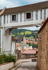 The view of St. Vitus church and the town of Cesky Krumlov from the castle courtyard framed by the Cloak Bridge. Český Krumlov, South Bohemia, Czech Republic.