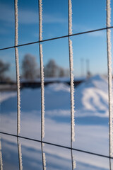 Very cold fence with snow flakes in winter