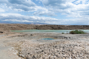 Sinkhole filled with turquoise water, near Dead Sea coastline. Hole formed when underground salt is dissolved by freshwater intrusion, due to continuing sea-level drop. . High quality photo