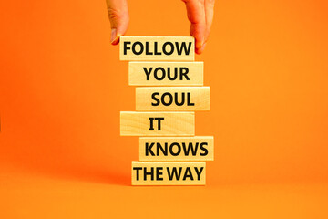 Motivation and inspiration symbol. Wood blocks with words Follow your soul it knows the way. Beautiful orange background. Businessman hand. Business motivation and inspiration concept. Copy space.