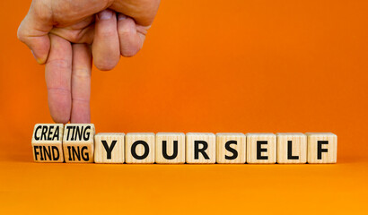 Finding or creating yourself symbol. Businessman turns wooden cubes and changes words Finding yourself to Creating yourself. Beautiful orange background copy space. Business creating yourself concept. - obrazy, fototapety, plakaty