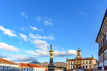 Fototapeta na wymiar Ouro Preto central square with its historic colonial-style buildings and mountains lit by the late afternoon sun