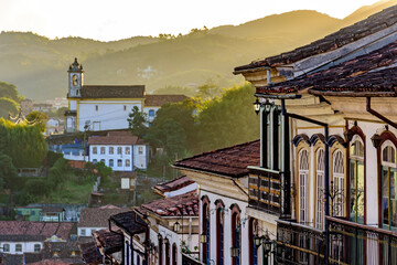 View of historic colonial style houses and church in the background on the hills of Ouro Preto...