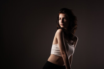 Fototapeta premium Beautiful teenage girl studio portrait against dark background..