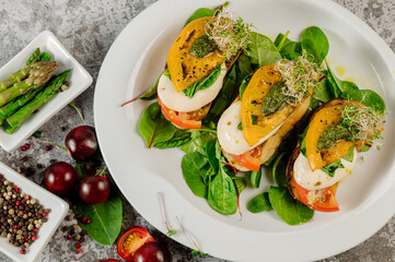 Croutons snacks with tomatoes, melted cheese and herbs on concrete background