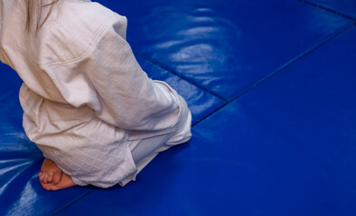 martial arts student sitting on mat. Close up