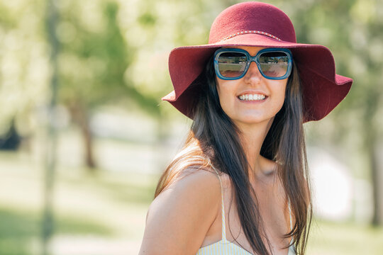 girl in summer with hat and sunglasses on the street