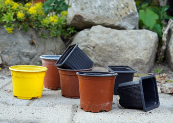 Naklejka premium Plastic small flower pots. It stands outside on the interlocking paving.