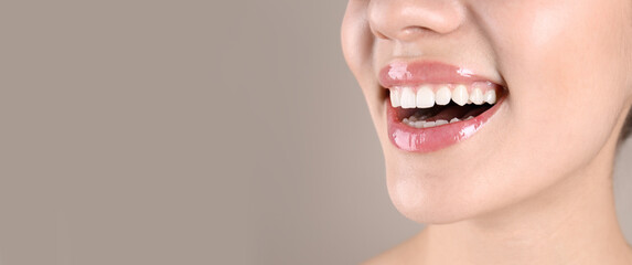 Closeup view of young woman with healthy teeth on beige background, space for text. Banner design
