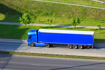 Blue semi truck lorry with trailer in motion on freeway. Big commercial cargo van, freight car. Branding mockup. © photoguns