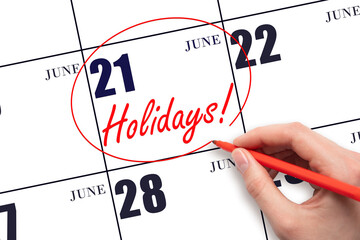 Hand drawing a red circle and writing the text Holidays on the calendar date 21 June. Important...