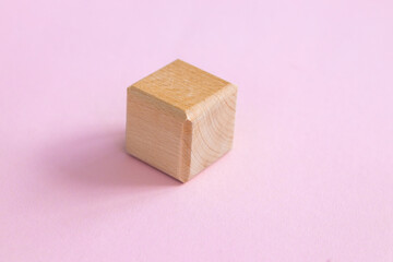 wooden geometric shapes cube isolated on a pink