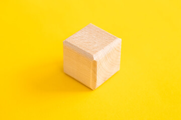 wooden geometric shapes cube isolated on a yellow