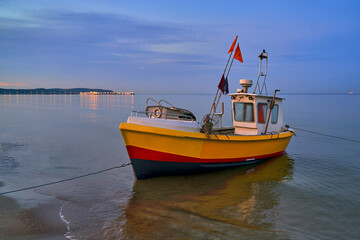 Naklejka na ściany i meble Picturesque moored fishing boat on beach in Sopot, Pomorskie region, Poland