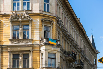 National flag of Ukraine on a vintage balcony of an old house on a sunny day in the historical center of Prague, Czech Republic, European solidarity with the fight against Russian military aggression